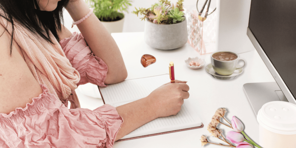 a woman sitting at a computer desk writing.